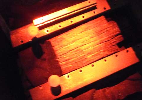 The larger piece of wood is shown being held in place for laser holographic recording.